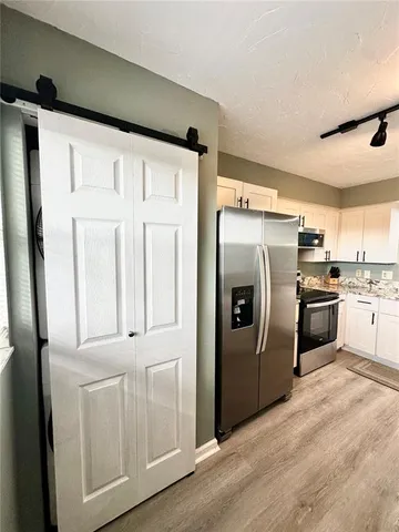 a kitchen with white cabinets and stainless steel appliances