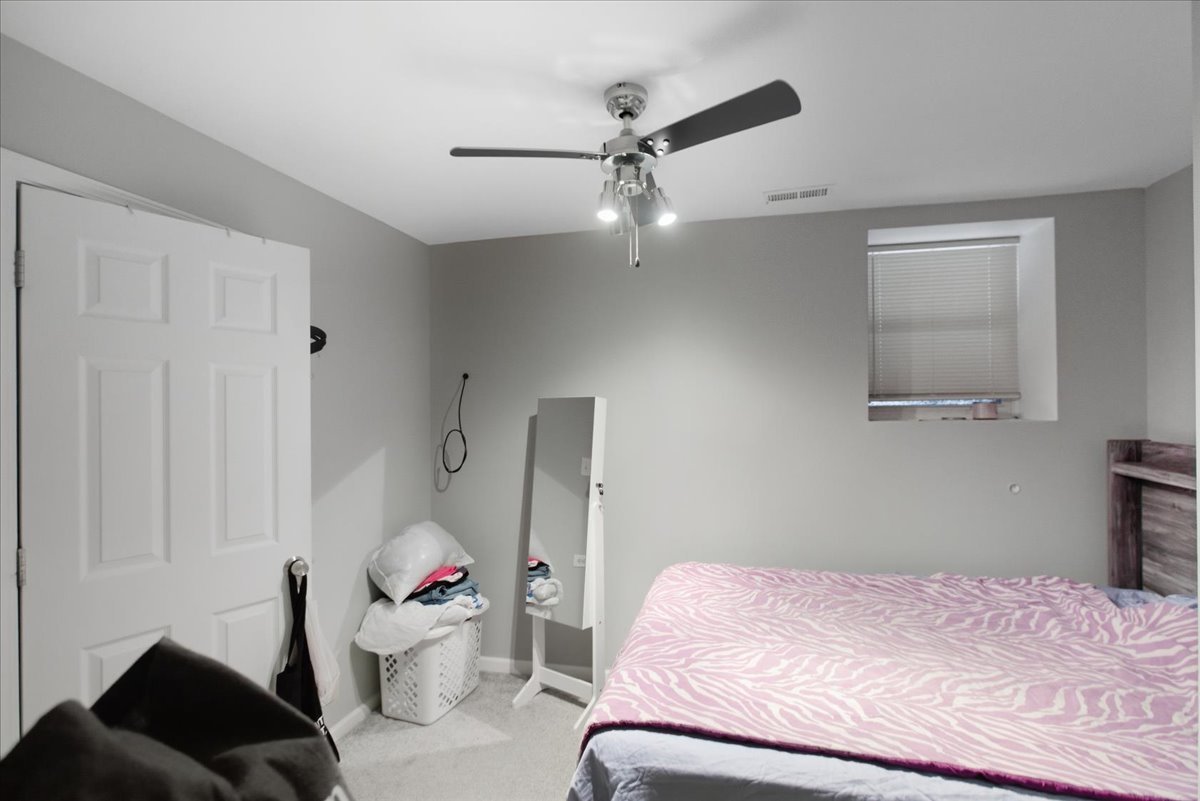 4423 South Prairie Avenue, Unit GARDEN Chicago, IL 60653 - Photo 11 of 13 a bedroom with a bed and a chandelier