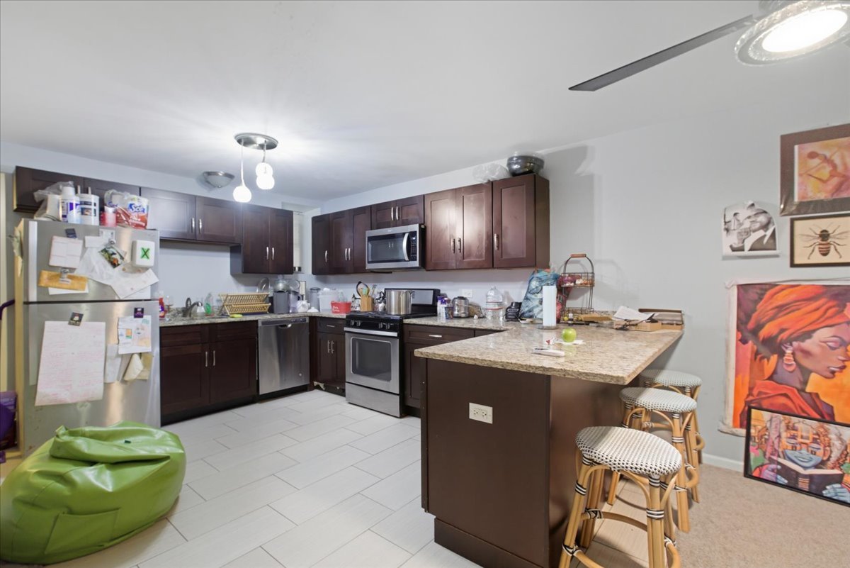 4423 South Prairie Avenue, Unit GARDEN Chicago, IL 60653 - Photo 6 of 13 a kitchen with stainless steel appliances granite countertop a sink and a refrigerator