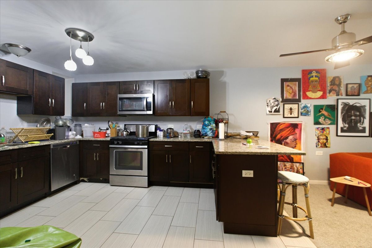 4423 South Prairie Avenue, Unit GARDEN Chicago, IL 60653 - Photo 7 of 13 a kitchen with stainless steel appliances granite countertop a refrigerator and a stove top oven