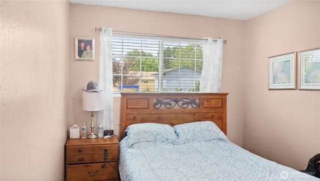a bed sitting in a bedroom next to a window