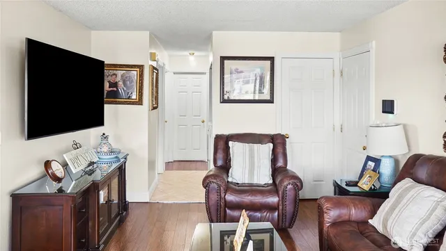 a living room with furniture a flat screen tv and wooden floor