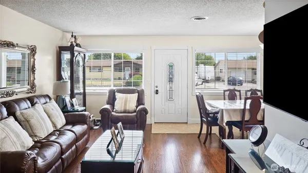 a living room with furniture a flat screen tv and a large window