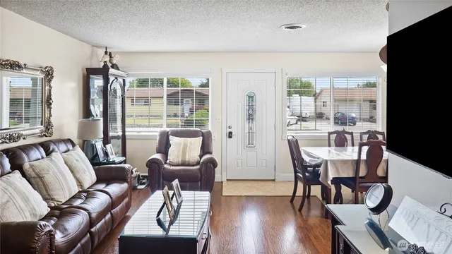 a living room with furniture a flat screen tv and a large window