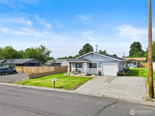 a front view of a house with a yard and potted plants