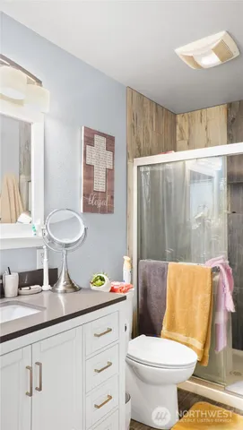 a bathroom with a granite countertop toilet sink and mirror