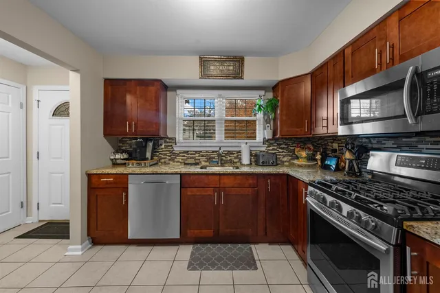 a kitchen with stainless steel appliances granite countertop a stove sink and cabinets