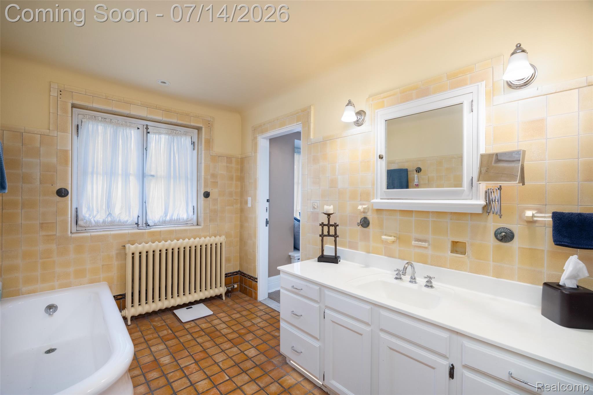 189 Cloverly Road Grosse Pointe, MI 48236 - Photo 44 of 96 Bathroom featuring a white bathtub, a window with curtains, and a prominent radiator