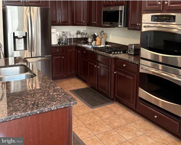 a kitchen with granite countertop a stove and a microwave