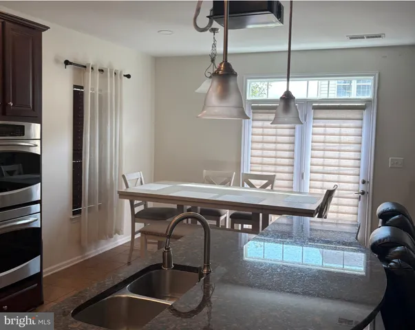 a kitchen with stainless steel appliances granite countertop a sink a stove and a refrigerator