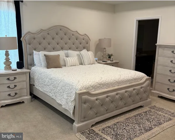 a bedroom with a bed a couch and a dresser