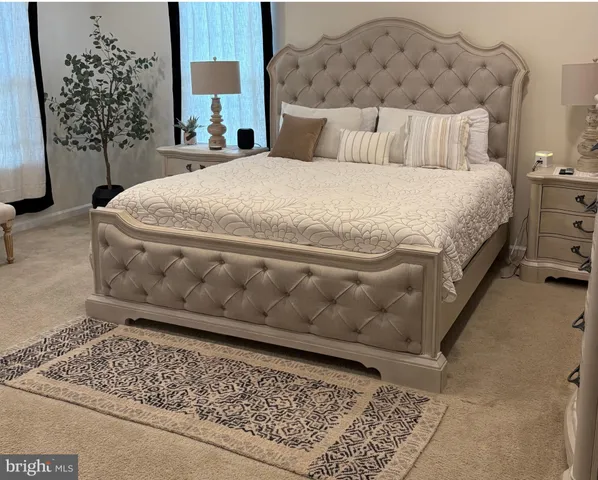 a large bed sitting in a bedroom next to a lamp