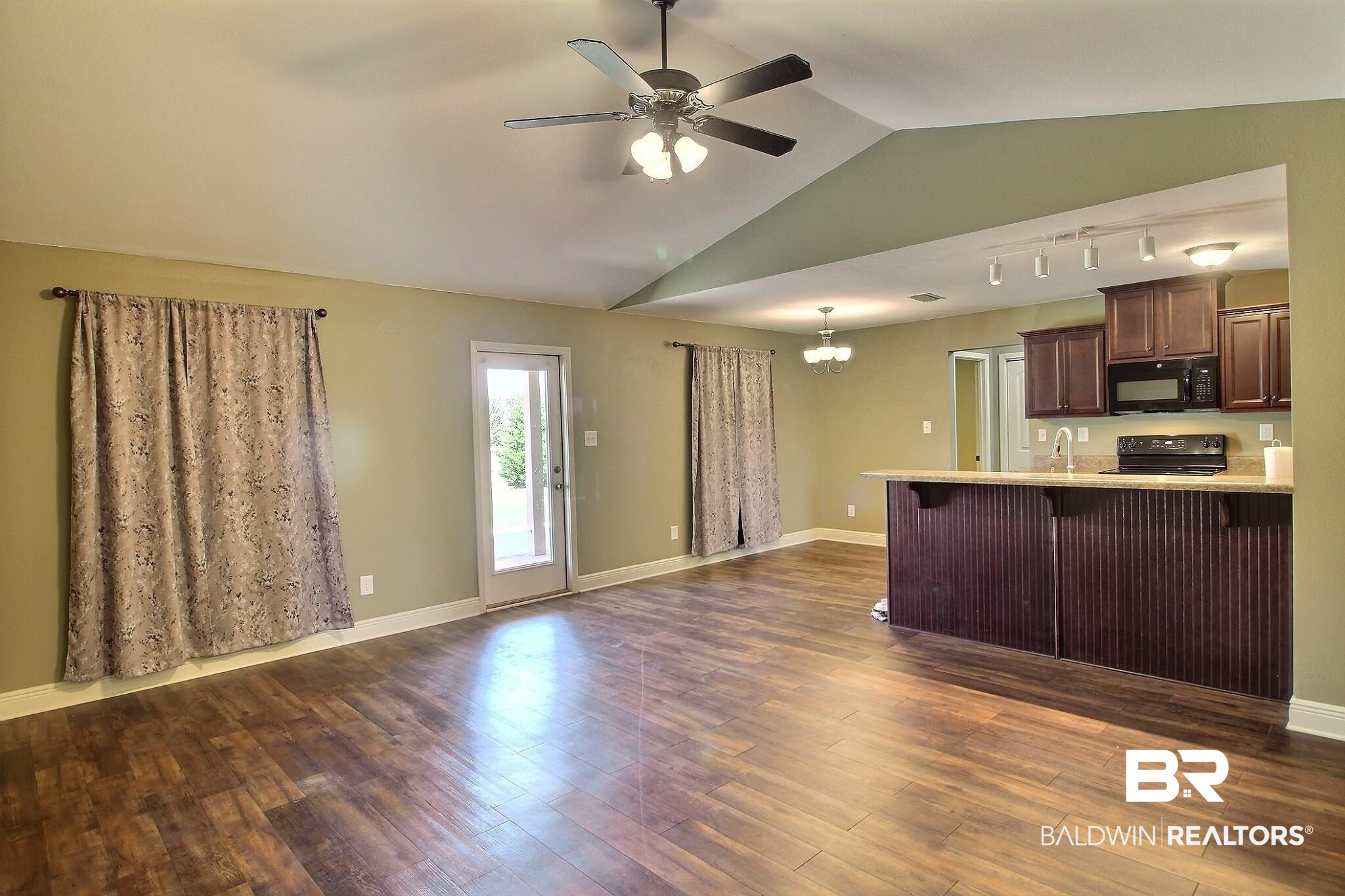 15577 Talus Court Foley, AL 36535 - Photo 25 of 28 Kitchen with a chandelier, a breakfast bar, dark brown cabinetry, open floor plan, and black appliances