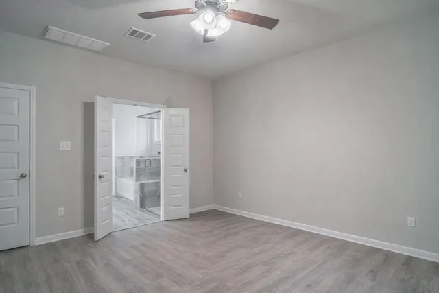 a view of an empty room with wooden floor