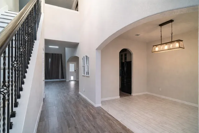 a view of a hallway with wooden floor and staircase