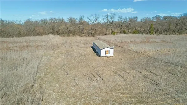 a view of a dry yard with trees