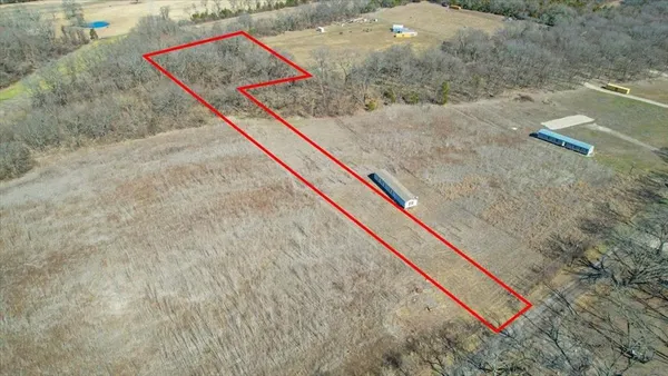 a view of a dry yard with trees