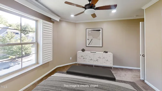 a view of an empty room with window and chandelier fan