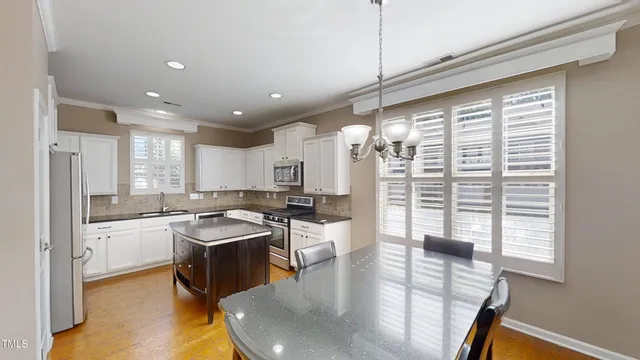 a kitchen with stainless steel appliances granite countertop sink stove and refrigerator