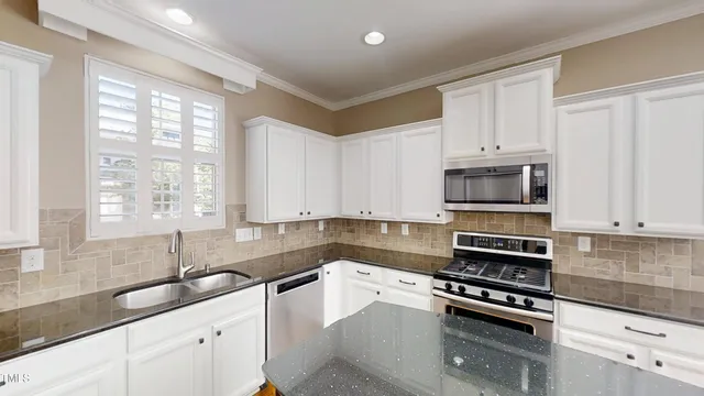 a kitchen with stainless steel appliances a sink stove and cabinets