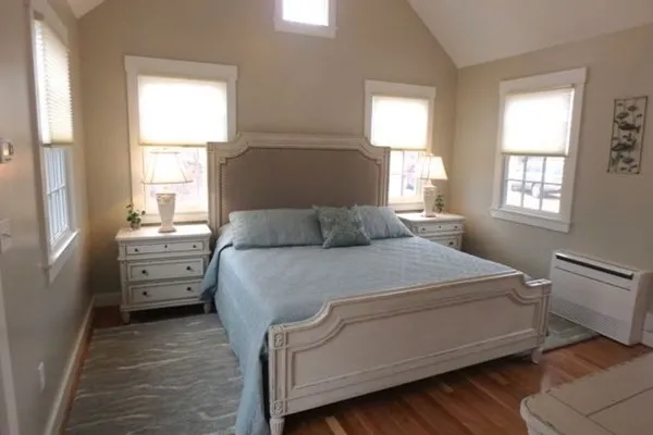 a bedroom with a bed and a dresser next to a window