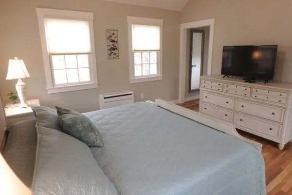 a bedroom with a flat screen tv and a bed