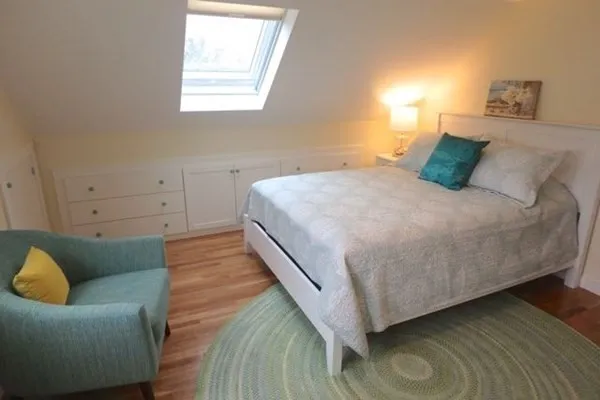 a bed sitting in a bedroom next to a window