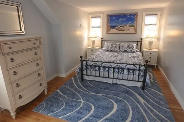 a bed sitting in a bedroom next to a window with a baby crib