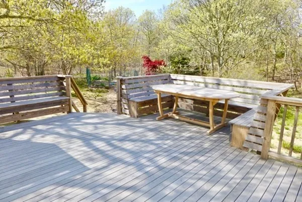 a view of a deck with table and chairs a barbeque with wooden floor and fence