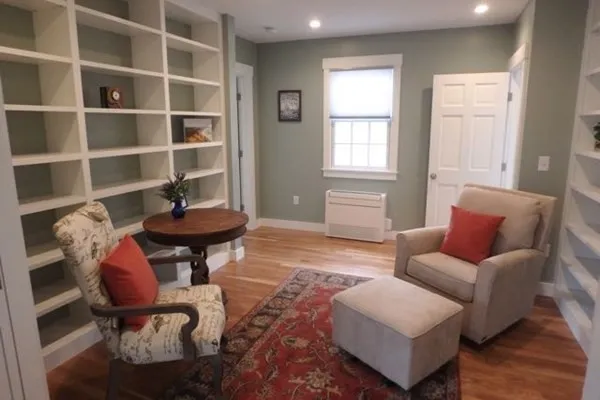 a living room with furniture a rug and a window
