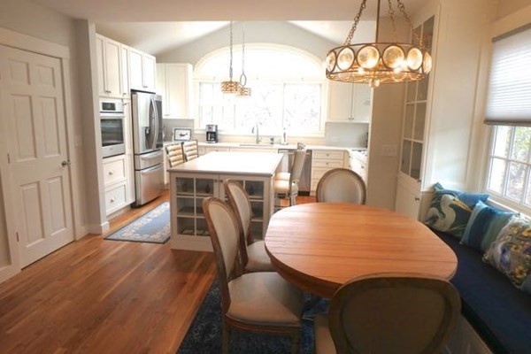 2 Strikers Way Chilmark, MA 02535 - Photo 9 of 33 a dining room with wooden floor a chandelier a wooden table and chairs