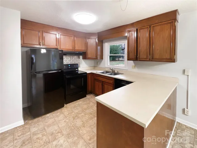 a kitchen with stainless steel appliances a refrigerator a sink a stove a microwave and wooden cabinets