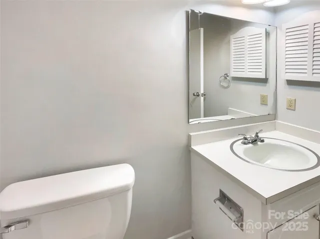 a bathroom with a sink a toilet and mirror