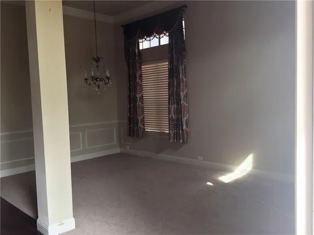 a view of an empty room with closet and a window