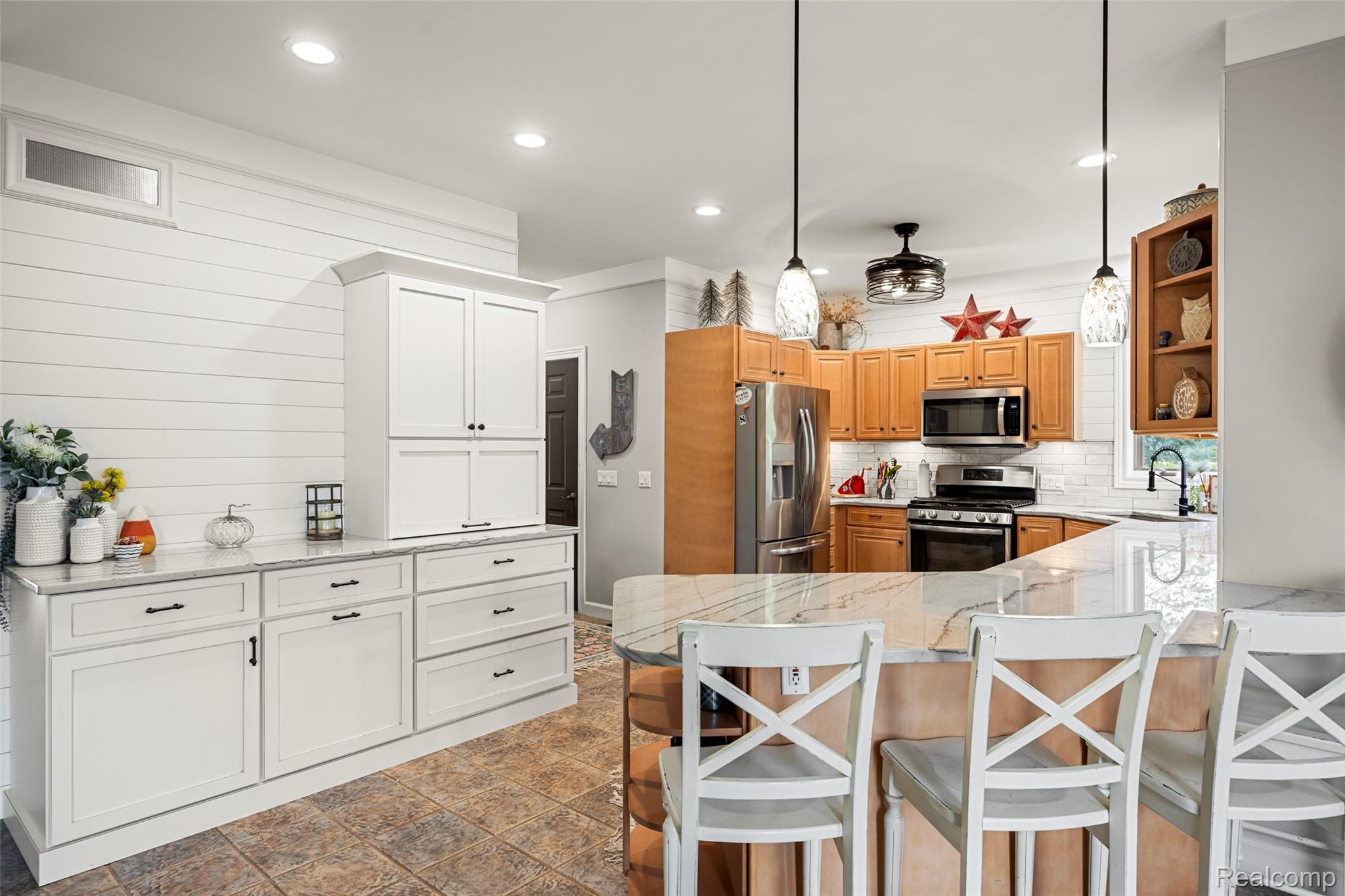 7030 Marsh Road Marine City, MI 48039 - Photo 14 of 47 Kitchen featuring open shelves, stainless steel appliances, light stone counters, a peninsula, and hanging light fixtures