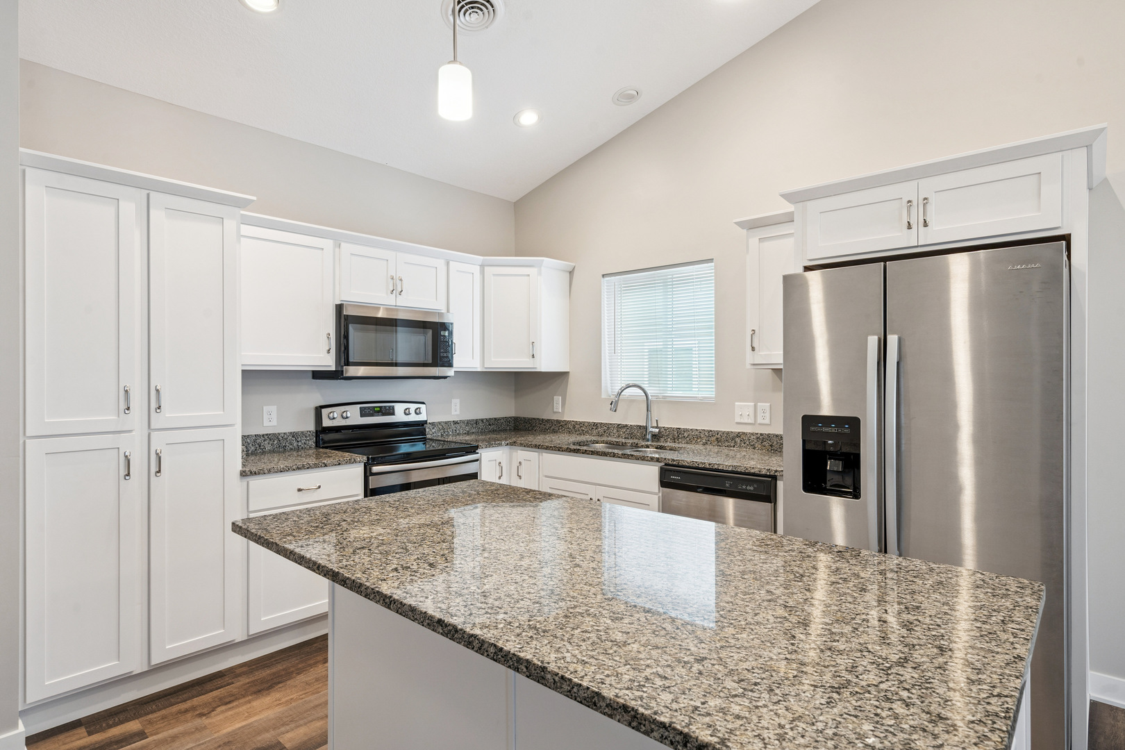 2406 13th Street Silvis, IL 61282 - Photo 7 of 22 a kitchen with stainless steel appliances granite countertop a refrigerator a stove and a sink with wooden floor