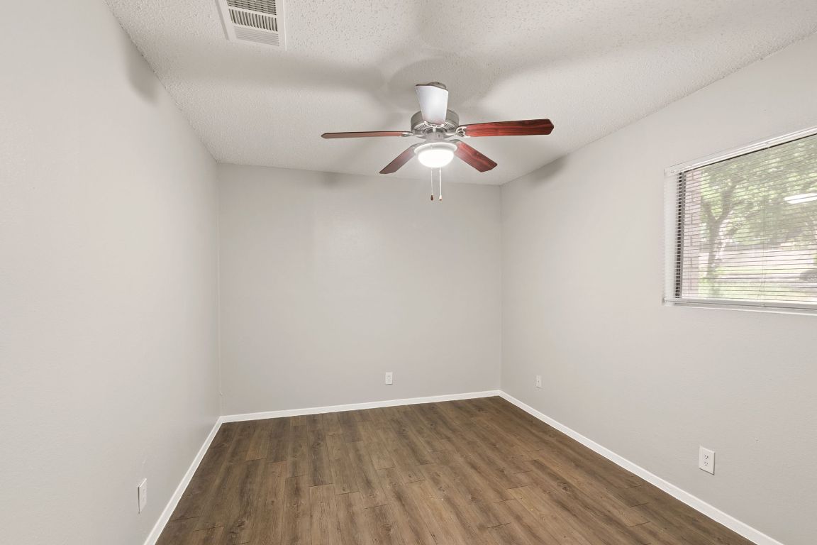 2001 South Interstate 35 Frontage Road, Unit 101 Austin, TX 78741 - Photo 13 of 24 an empty room with wooden floor fan and windows