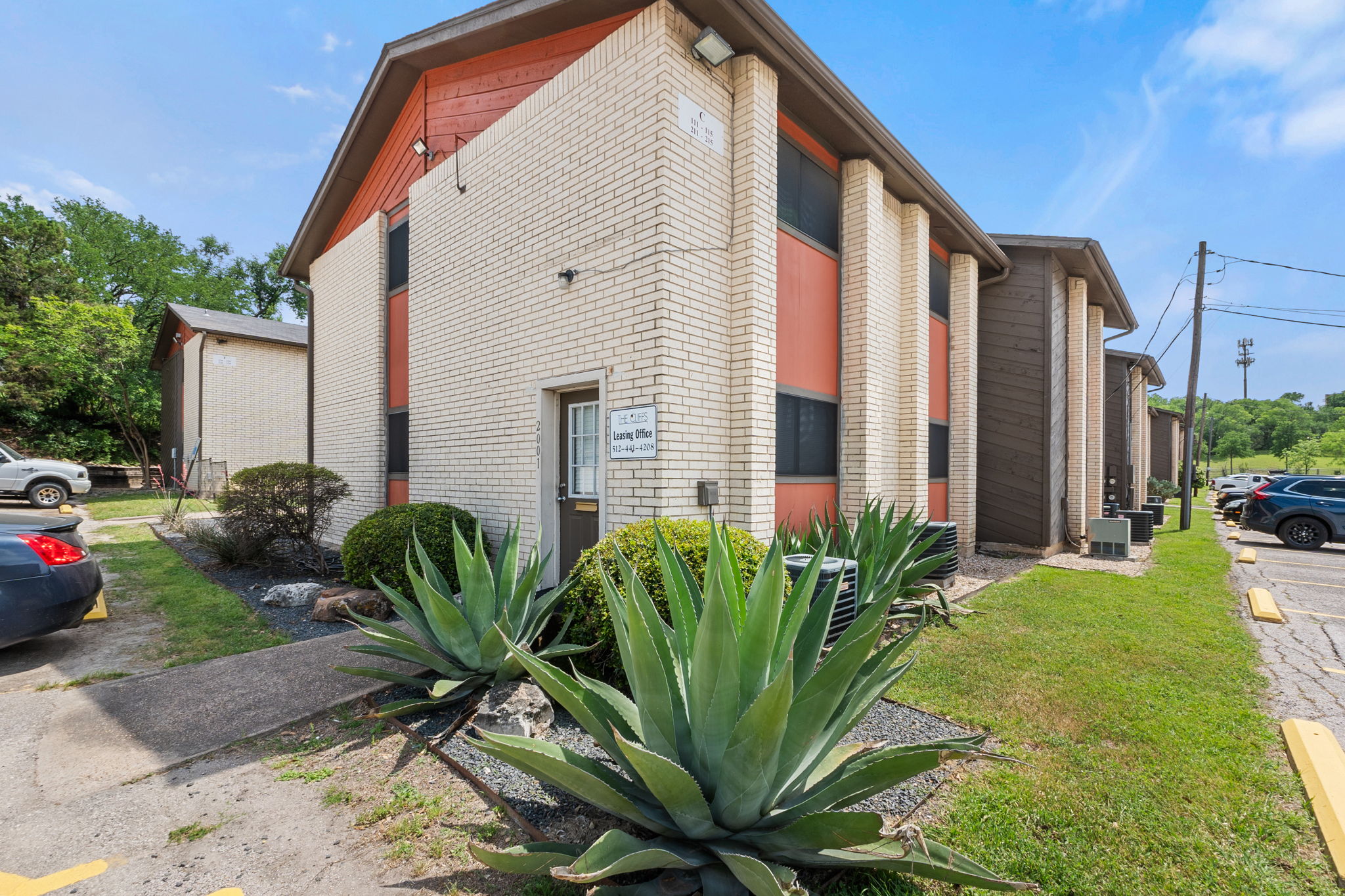 2001 South Interstate 35 Frontage Road, Unit 229 Austin, TX 78741 - Photo 24 of 24 View of home's exterior with brick siding, uncovered parking, and a lawn