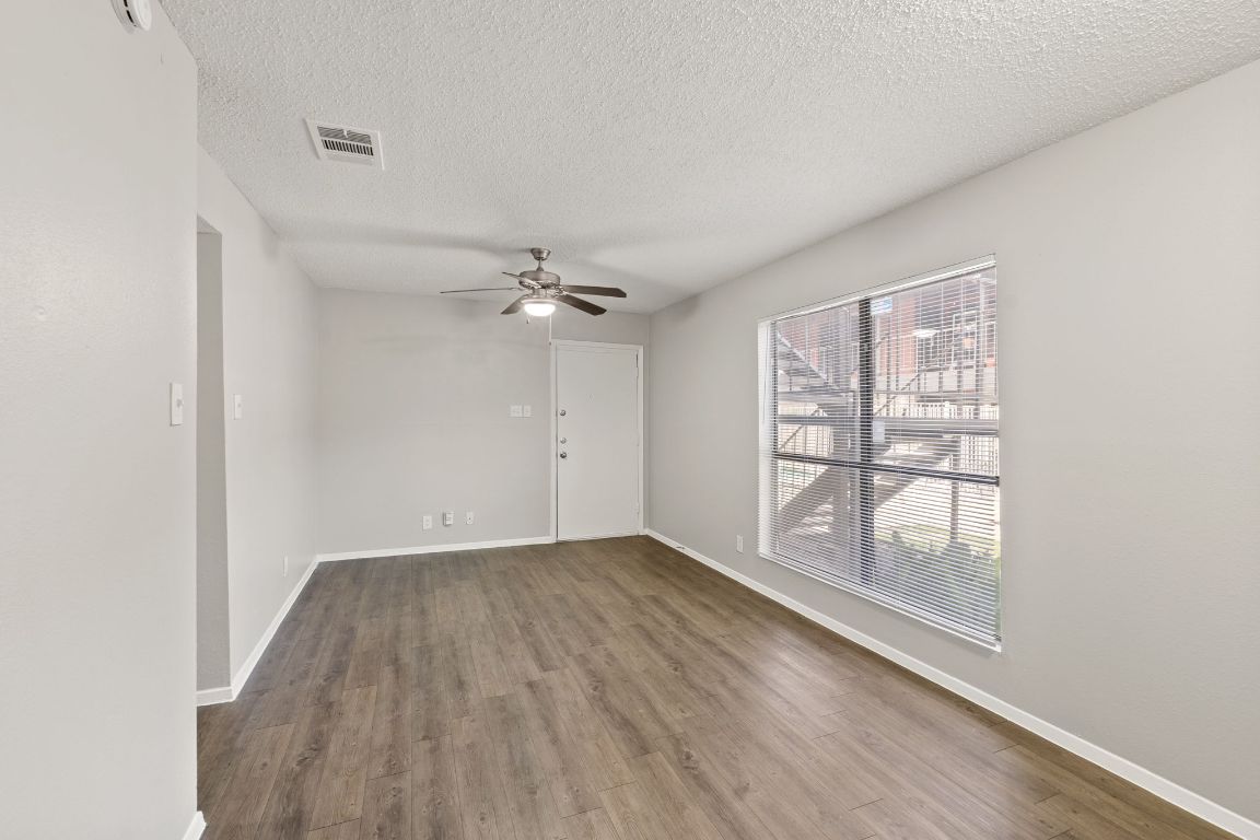 2001 South Interstate 35 Frontage Road, Unit 101 Austin, TX 78741 - Photo 9 of 24 an empty room with wooden floor fan and windows