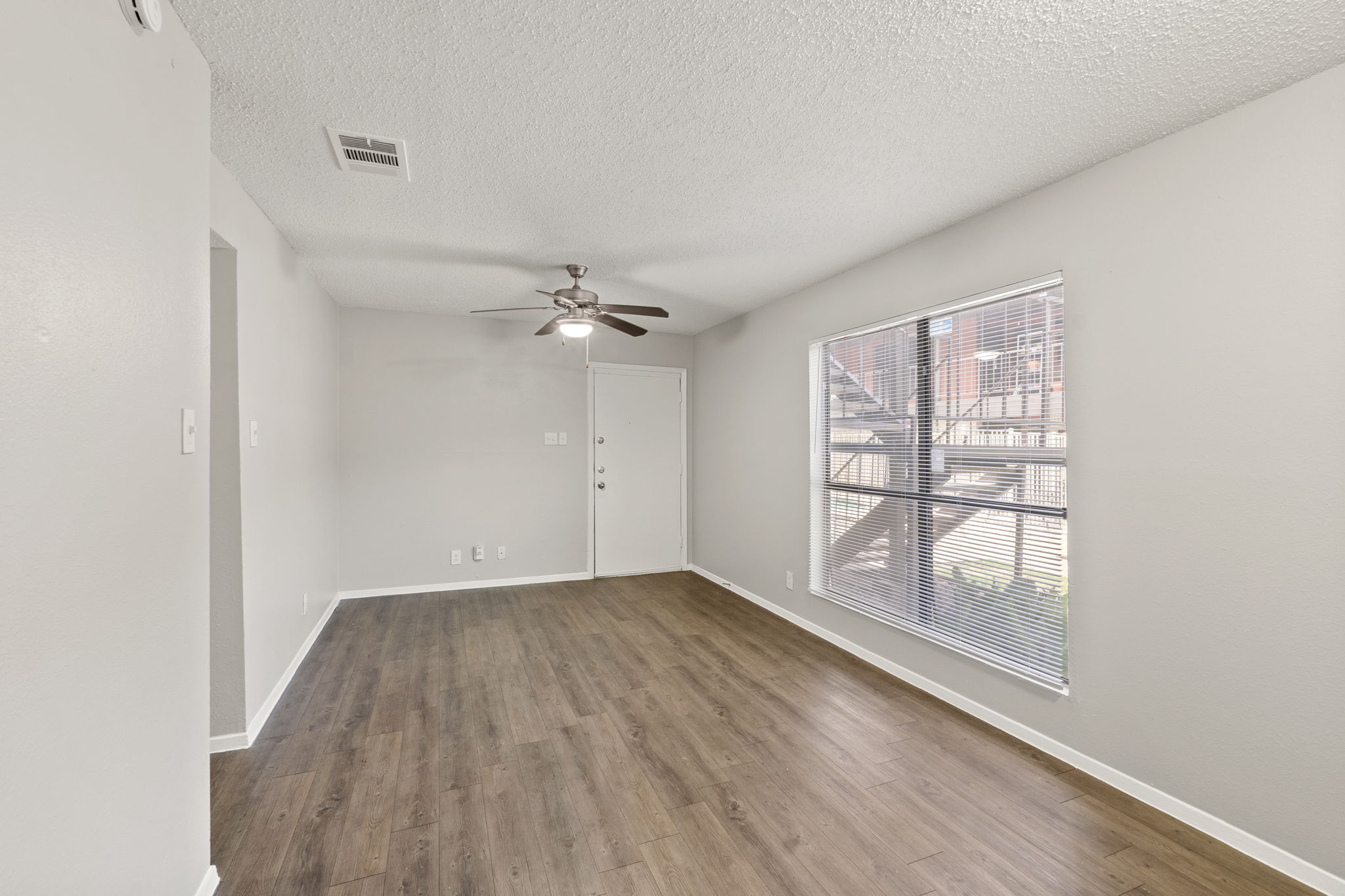 2001 South Interstate 35 Frontage Road, Unit 229 Austin, TX 78741 - Photo 9 of 24 Unfurnished room featuring dark wood finished floors, a textured ceiling, and ceiling fan