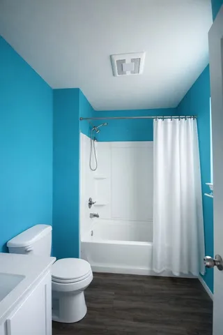 a bathroom with a toilet and a shower