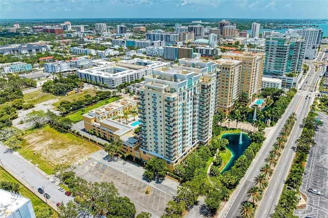 an aerial view of a residential building with an outdoor space and seating