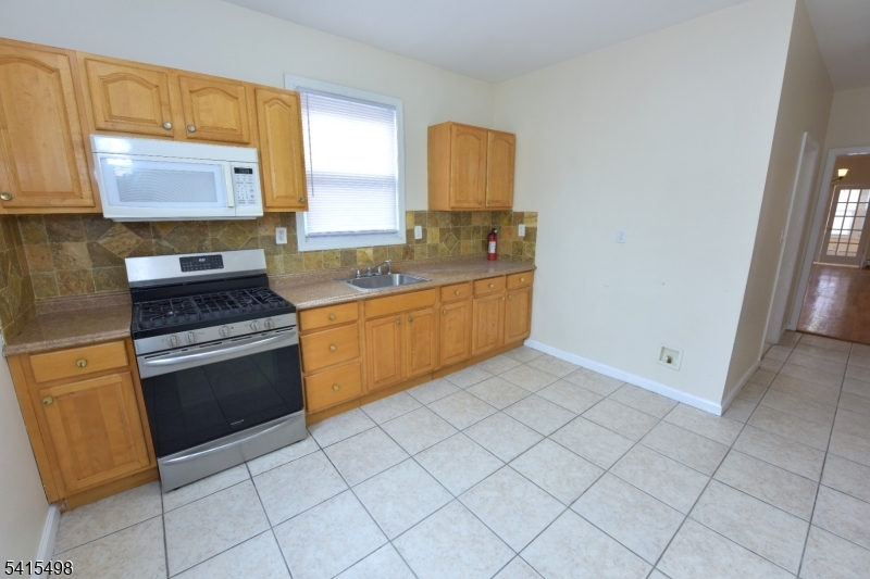 117 Scheerer Avenue Newark, NJ 07112 - Photo 12 of 19 a kitchen with cabinets a sink and appliances