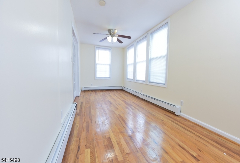 117 Scheerer Avenue Newark, NJ 07112 - Photo 14 of 19 wooden floor in an empty room with a window