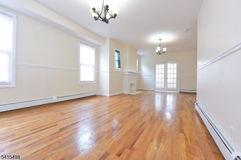 117 Scheerer Avenue Newark, NJ 07112 - Photo 19 of 19 an empty room with wooden floor and windows