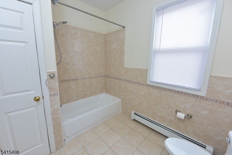 117 Scheerer Avenue Newark, NJ 07112 - Photo 2 of 19 a bathroom with a tub and a shower