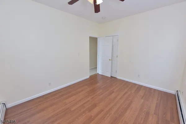 a view of an empty room with wooden floor