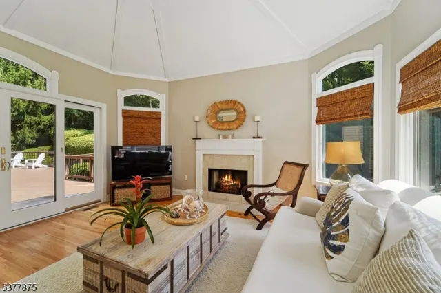 a living room with furniture a fireplace and floor to ceiling windows