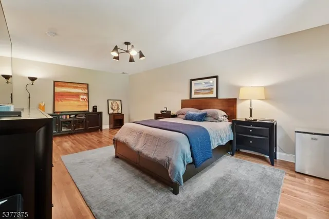 a spacious bedroom with a bed and dresser with mirror