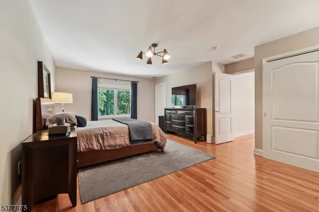 a spacious bedroom with a bed dresser and a window